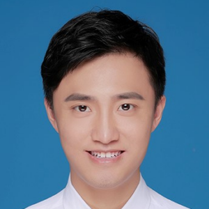A young man with short black hair smiles at the camera. He is wearing a white collared shirt and is posed in front of a solid blue background.