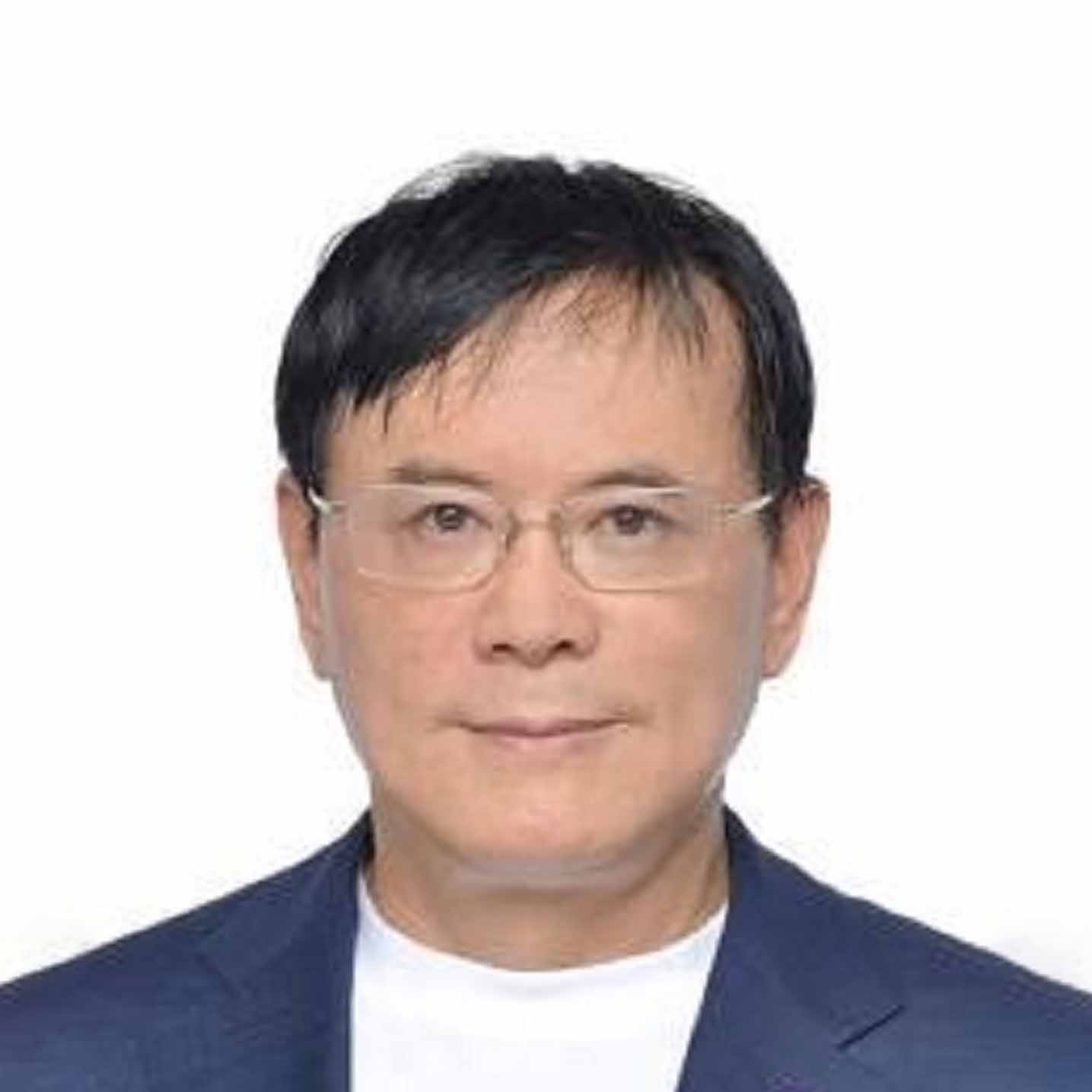 A middle-aged man with short black hair, wearing glasses, a white shirt, and a dark blue jacket, poses against a plain white background.